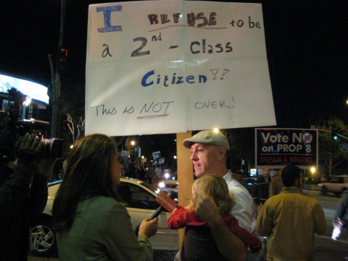 holding his adopted daughter, this man spoke eloquently to a reporter on the passage of prop 8